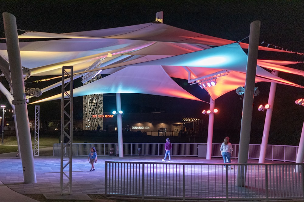 a group of people walking around a park at night