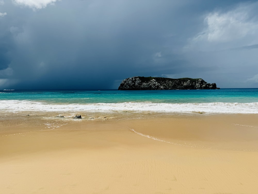 a large body of water sitting on top of a sandy beach