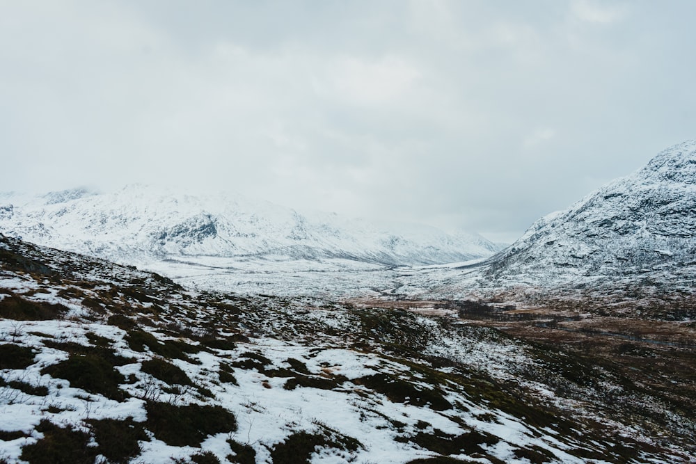 a snow covered mountain with a valley in the foreground