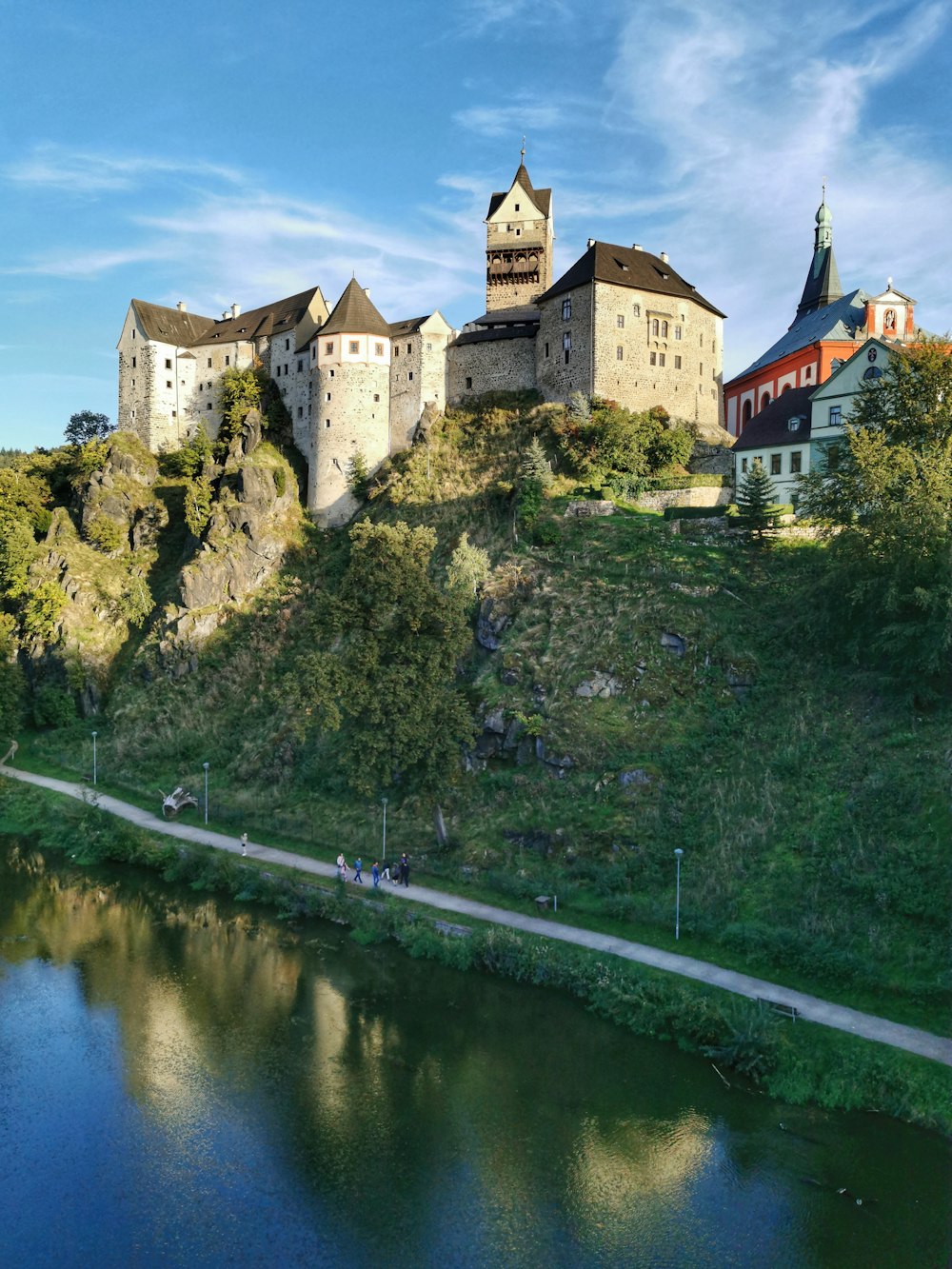 a castle on top of a hill next to a river
