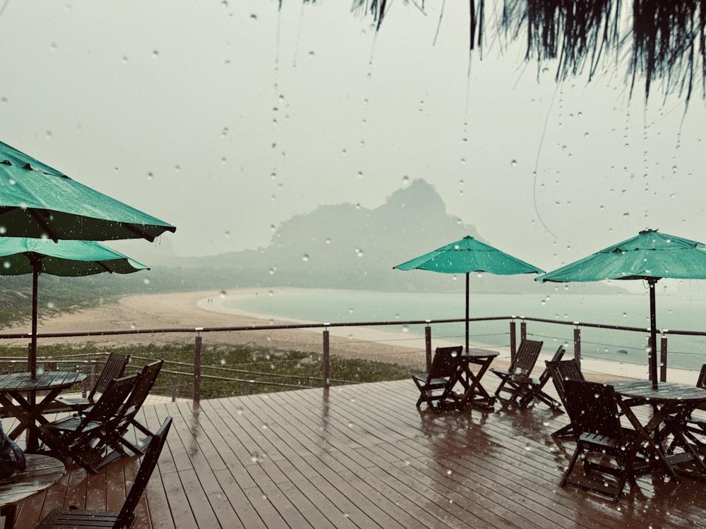 a wooden deck with tables and umbrellas on it