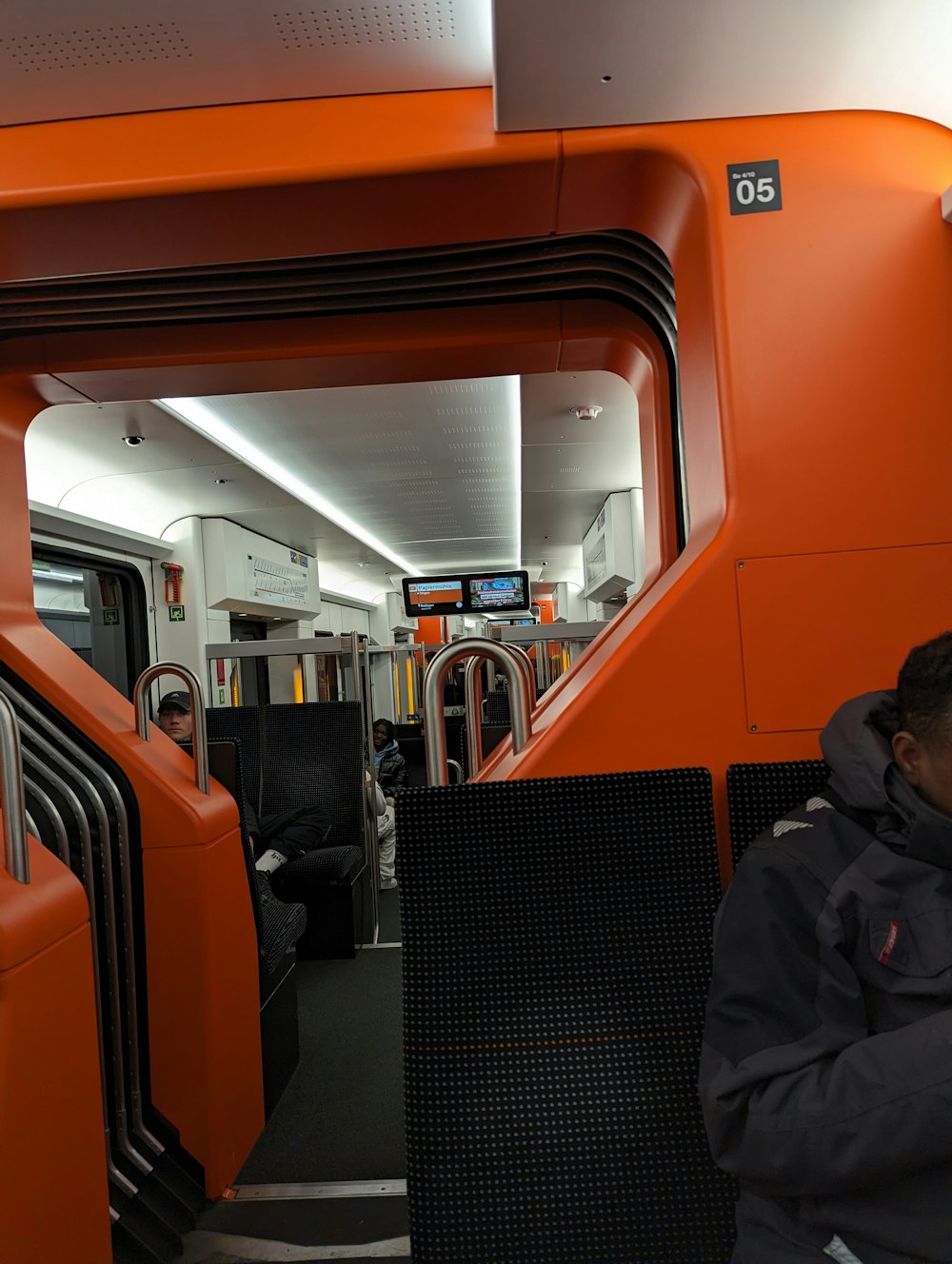 a man sitting on a train looking at his cell phone