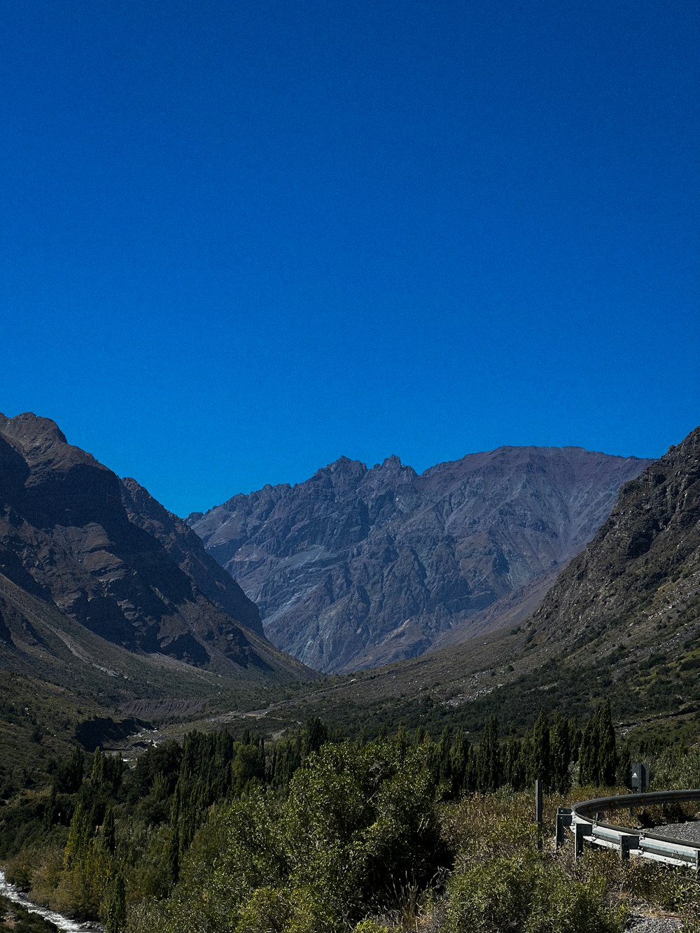 a scenic view of a valley with mountains in the background