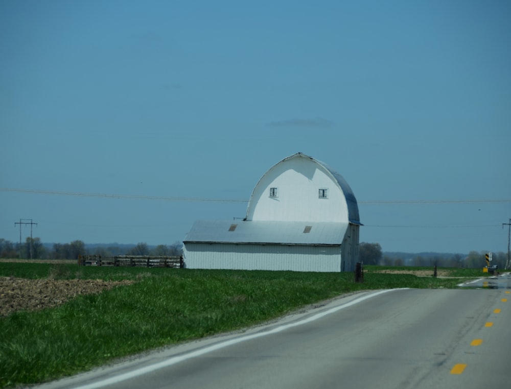 a large white barn sitting on the side of a road