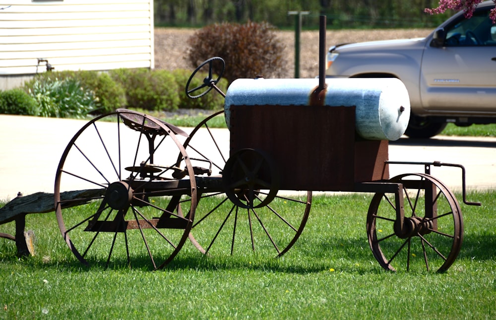 a horse drawn carriage sitting on top of a lush green field