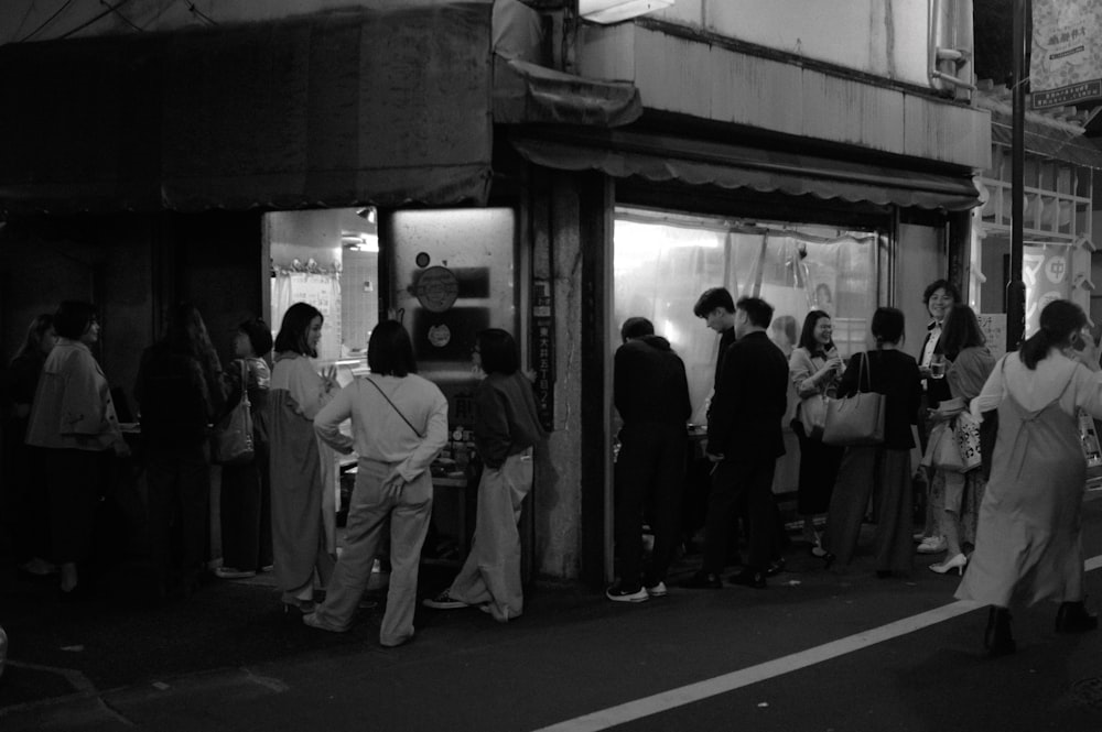 a group of people standing outside of a store