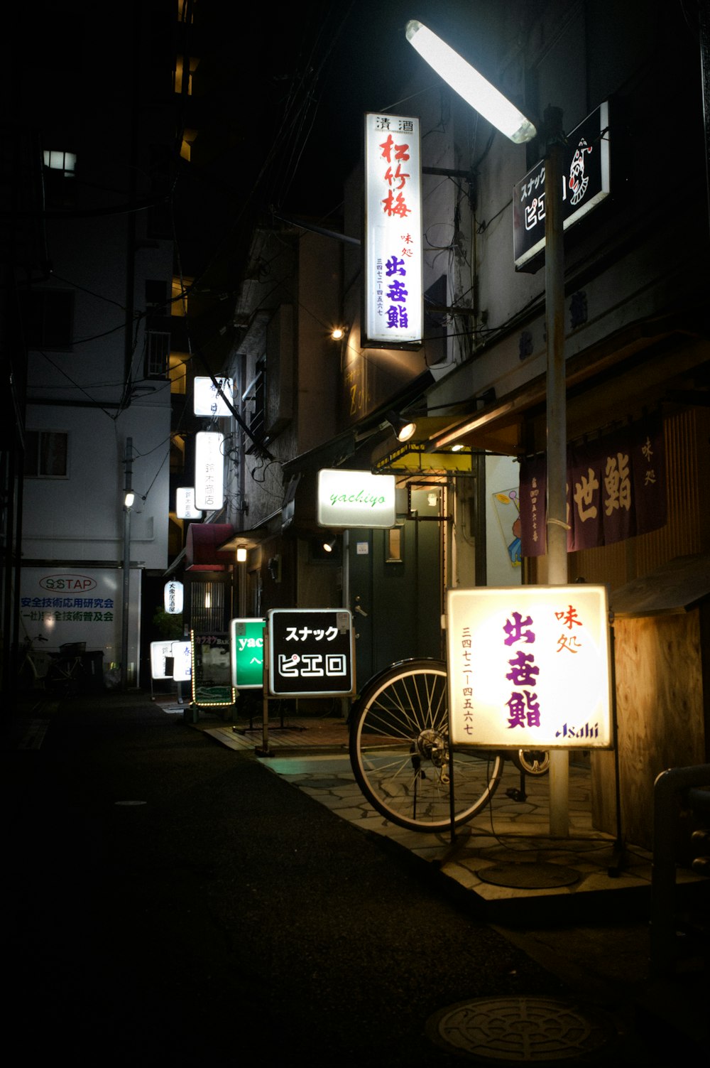 a bike parked on the side of a street at night