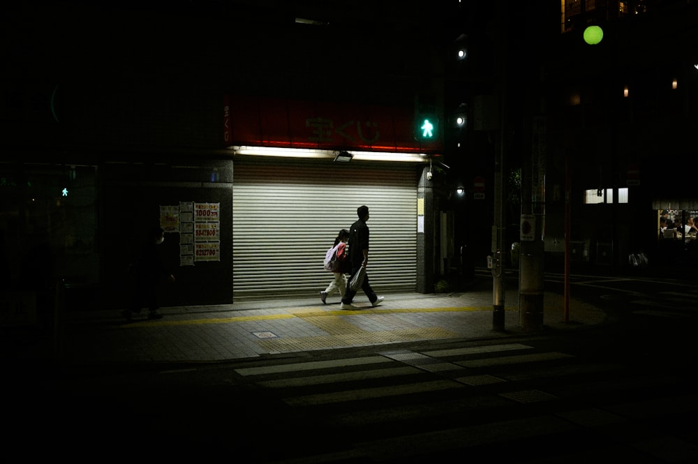 a person walking down a street at night