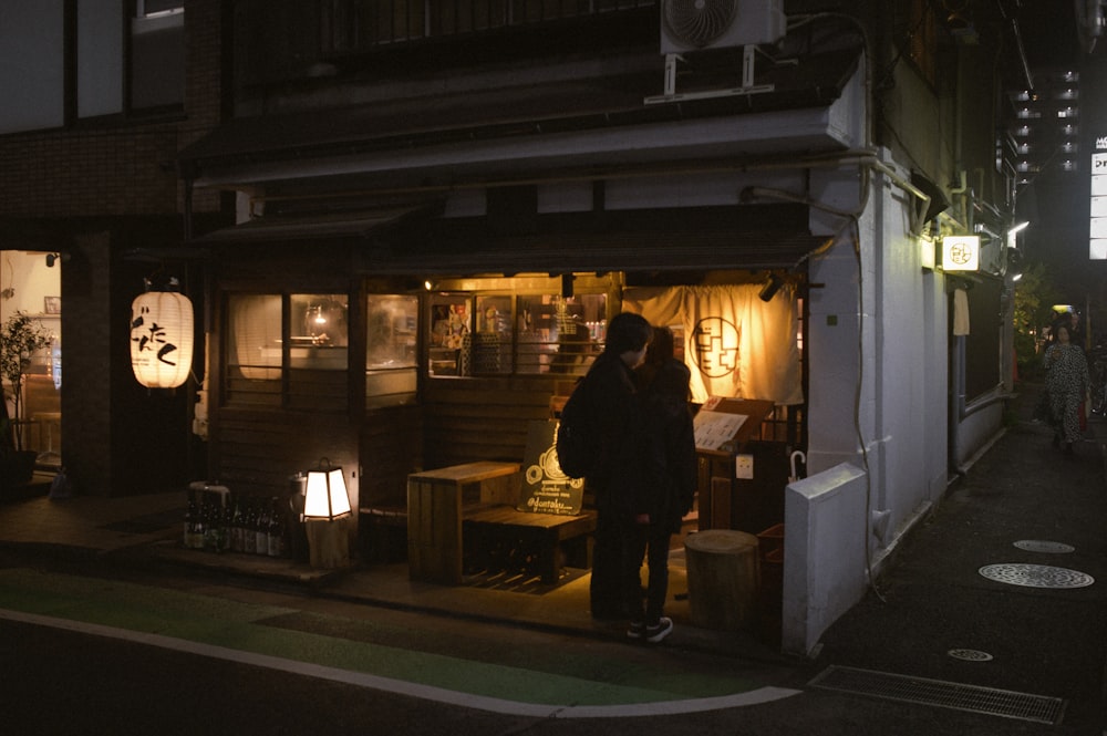 a man standing outside of a store at night