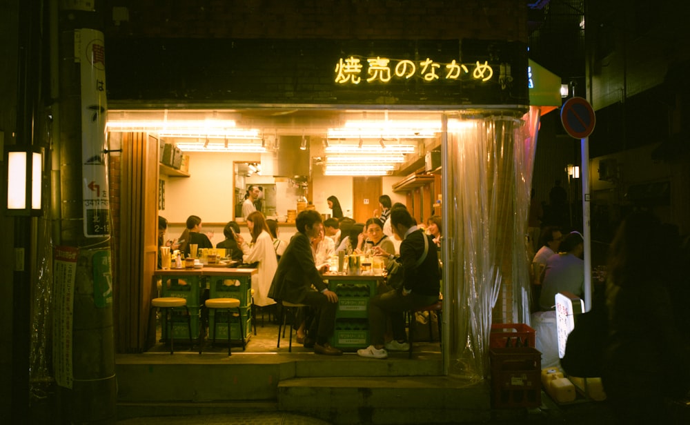 밤에 식당 밖에 서 있는 한 무리의 사람들