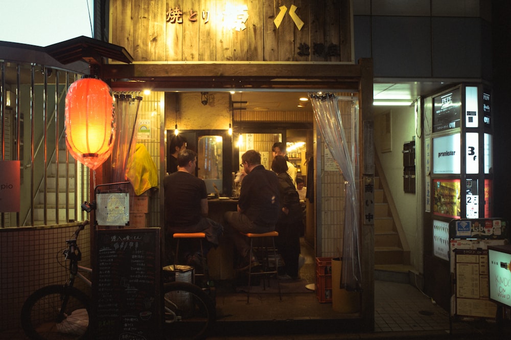 Un grupo de personas sentadas en una mesa fuera de un restaurante