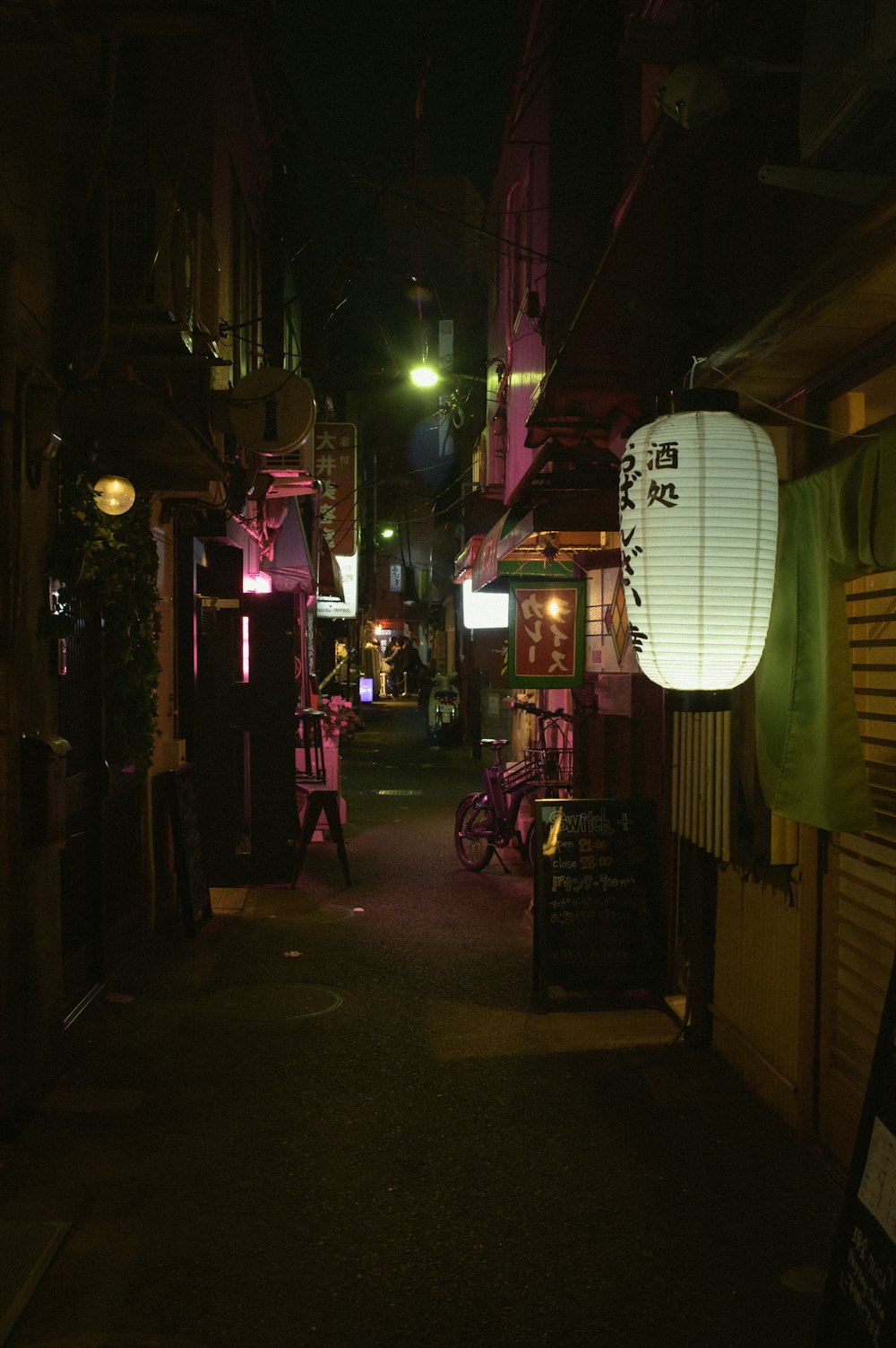 une ruelle sombre avec une lanterne suspendue au plafond