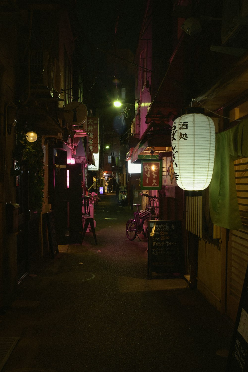 a dark alley with a lantern hanging from the ceiling