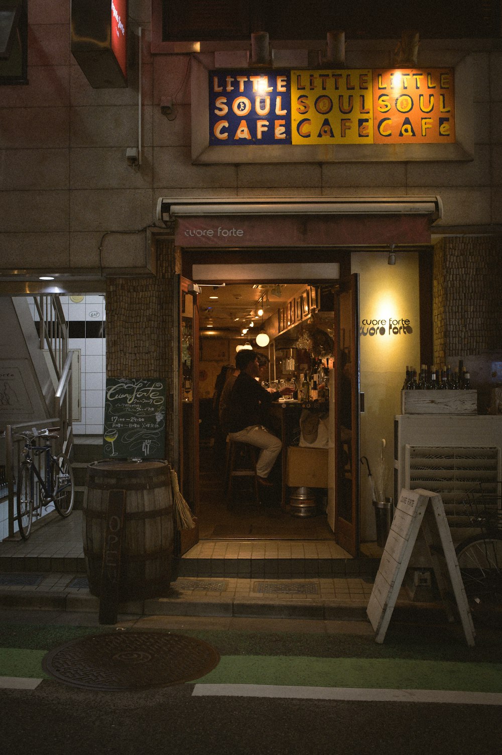 a person sitting at a table outside of a cafe