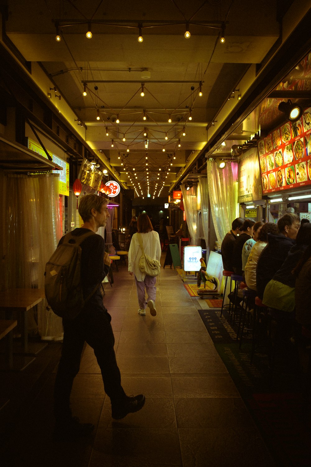 a group of people walking down a long hallway