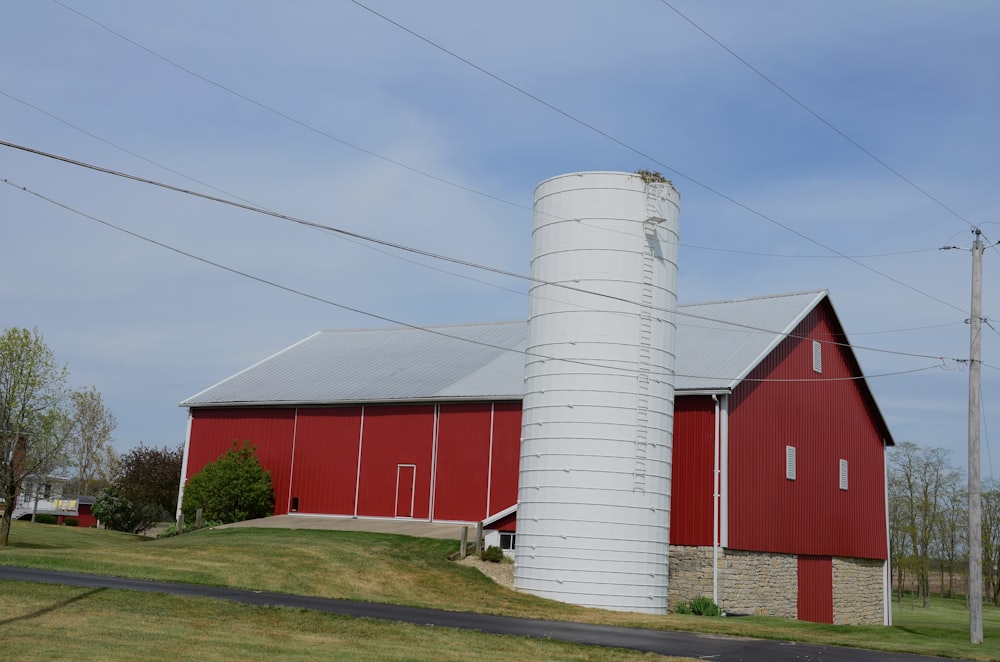 a red barn with a white silo in front of it