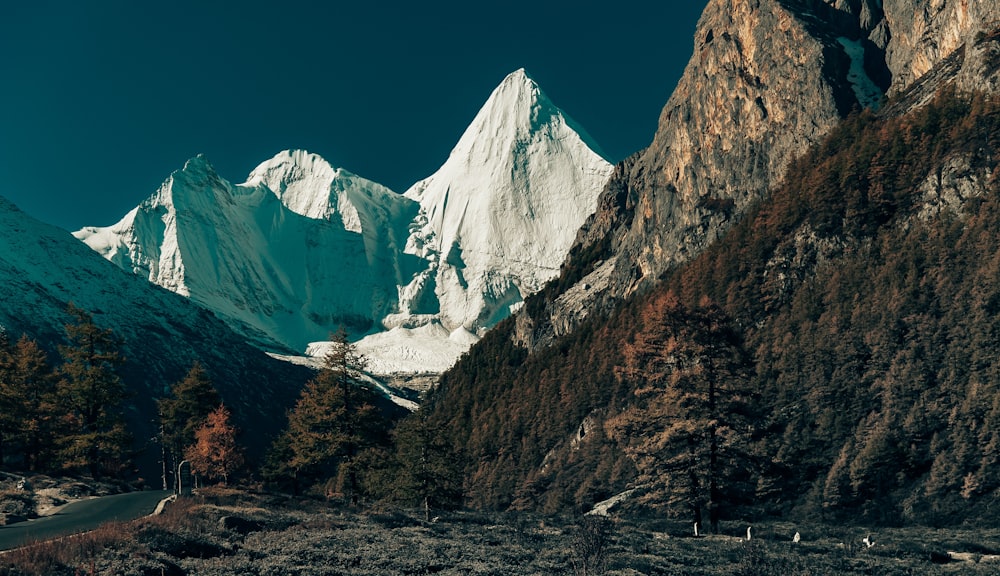 a snow covered mountain with a road going through it