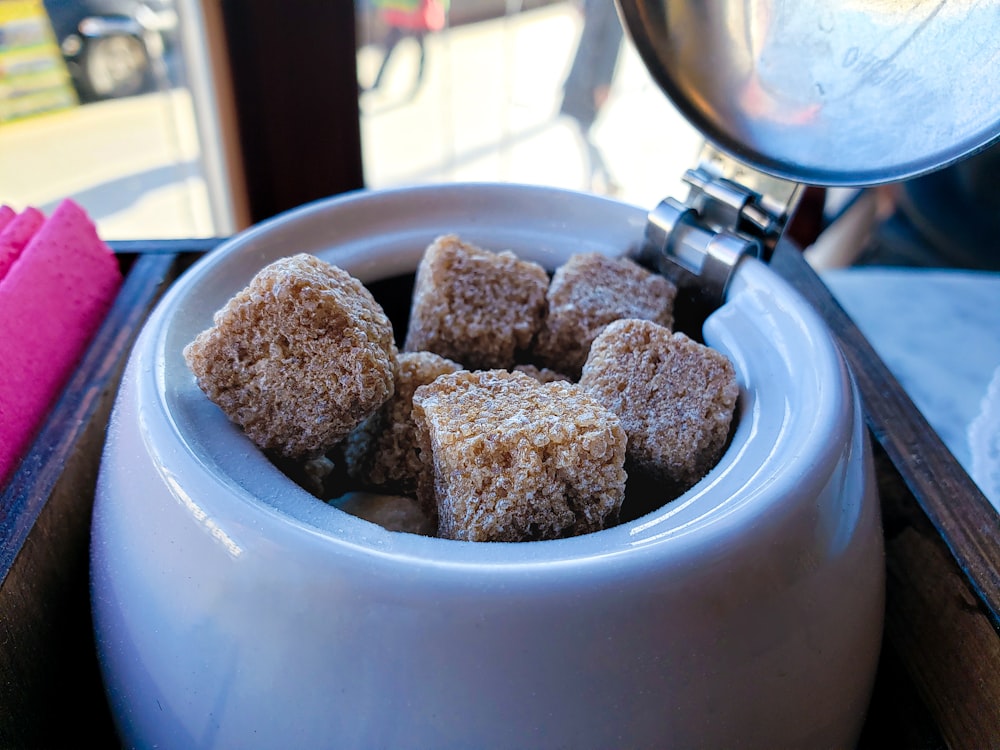 a bowl of sugar cubes sitting on a table