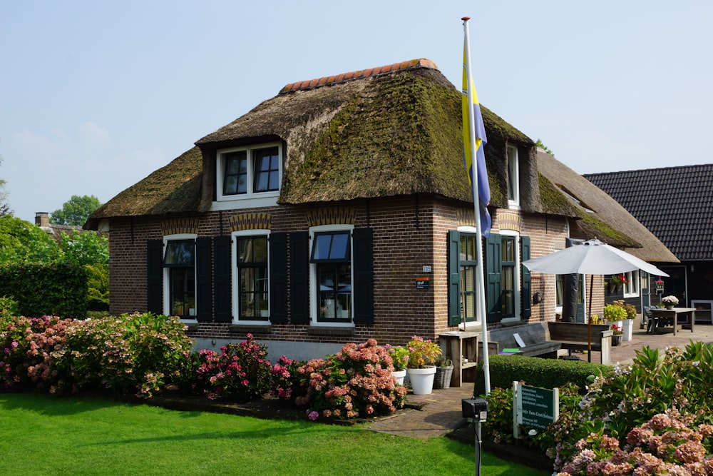 a house with a thatched roof and a green lawn