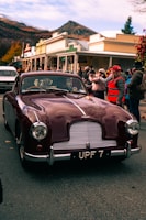 a maroon car parked on the side of the road