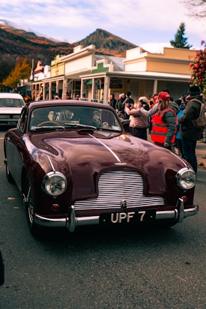 a maroon car parked on the side of the road