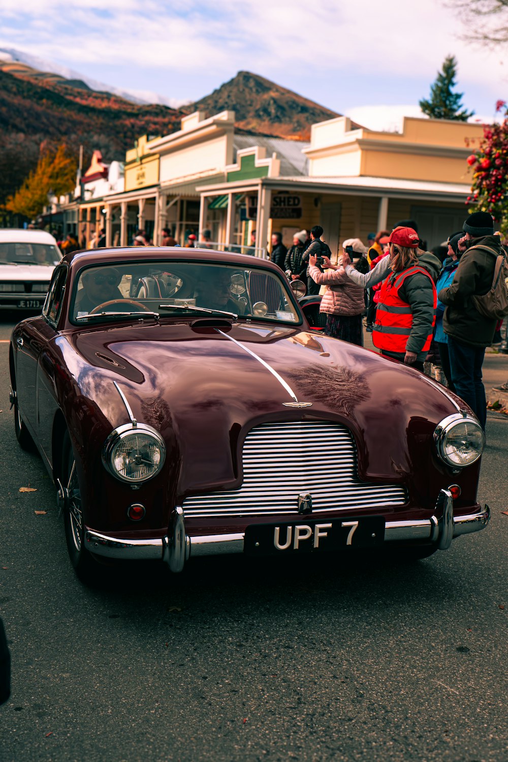 a maroon car parked on the side of the road