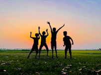 a group of people standing on top of a lush green field