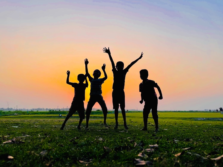 a group of people standing on top of a lush green field