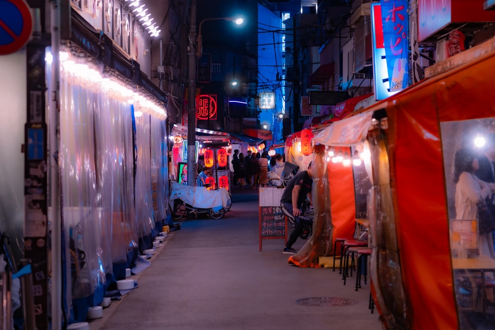 a narrow alley with a lot of people walking around