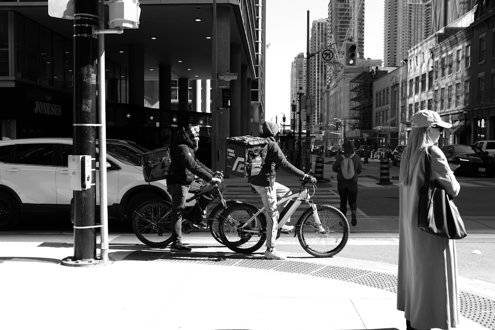 a black and white photo of people on bicycles