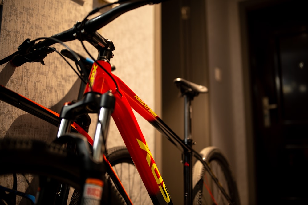 a red bike parked in a room next to a wall