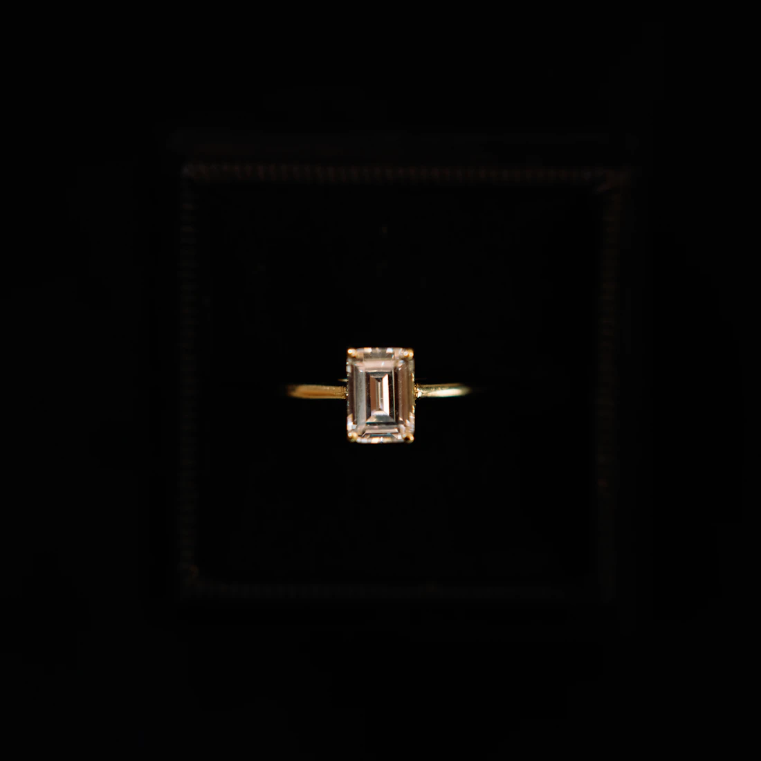 Emerald-cut diamond solitaire on a fine knife-edge band