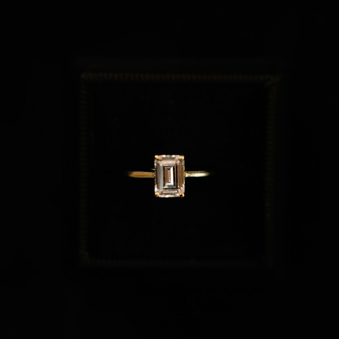 Emerald-cut diamond solitaire on a fine knife-edge band