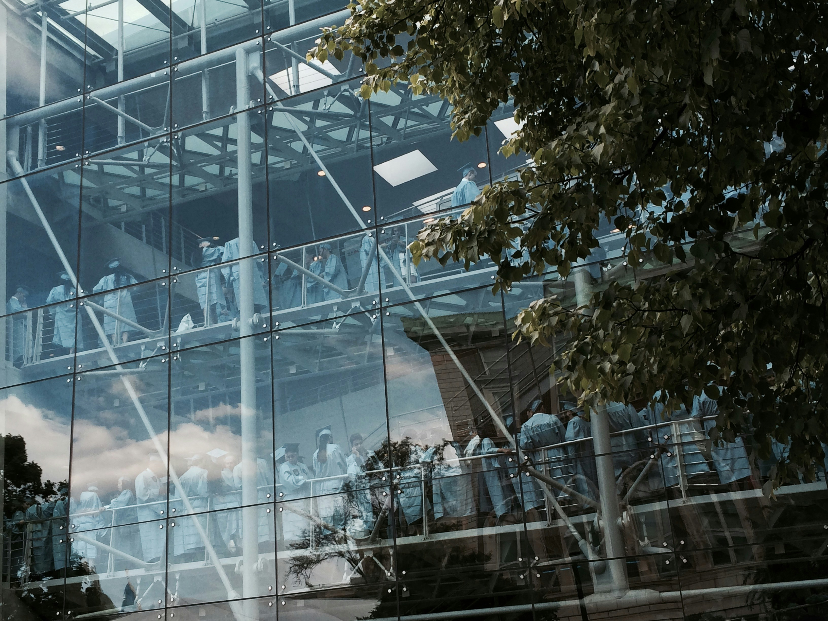 a reflection of a group of people in a glass building