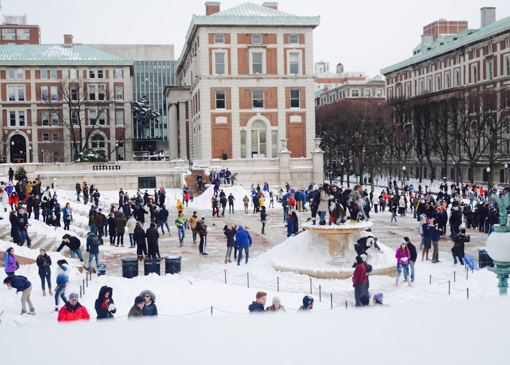 a group of people standing around a fountain in the snow