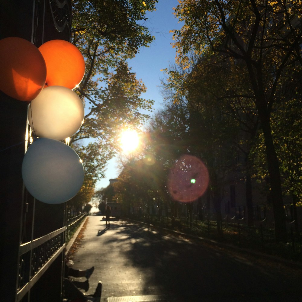 a bunch of balloons are hanging on a fence