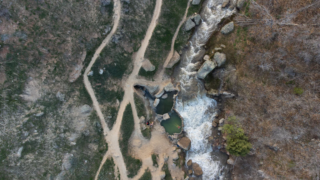 森を蛇行する川を上空から見た写真。人生の中間点と分岐を象徴するイメージ