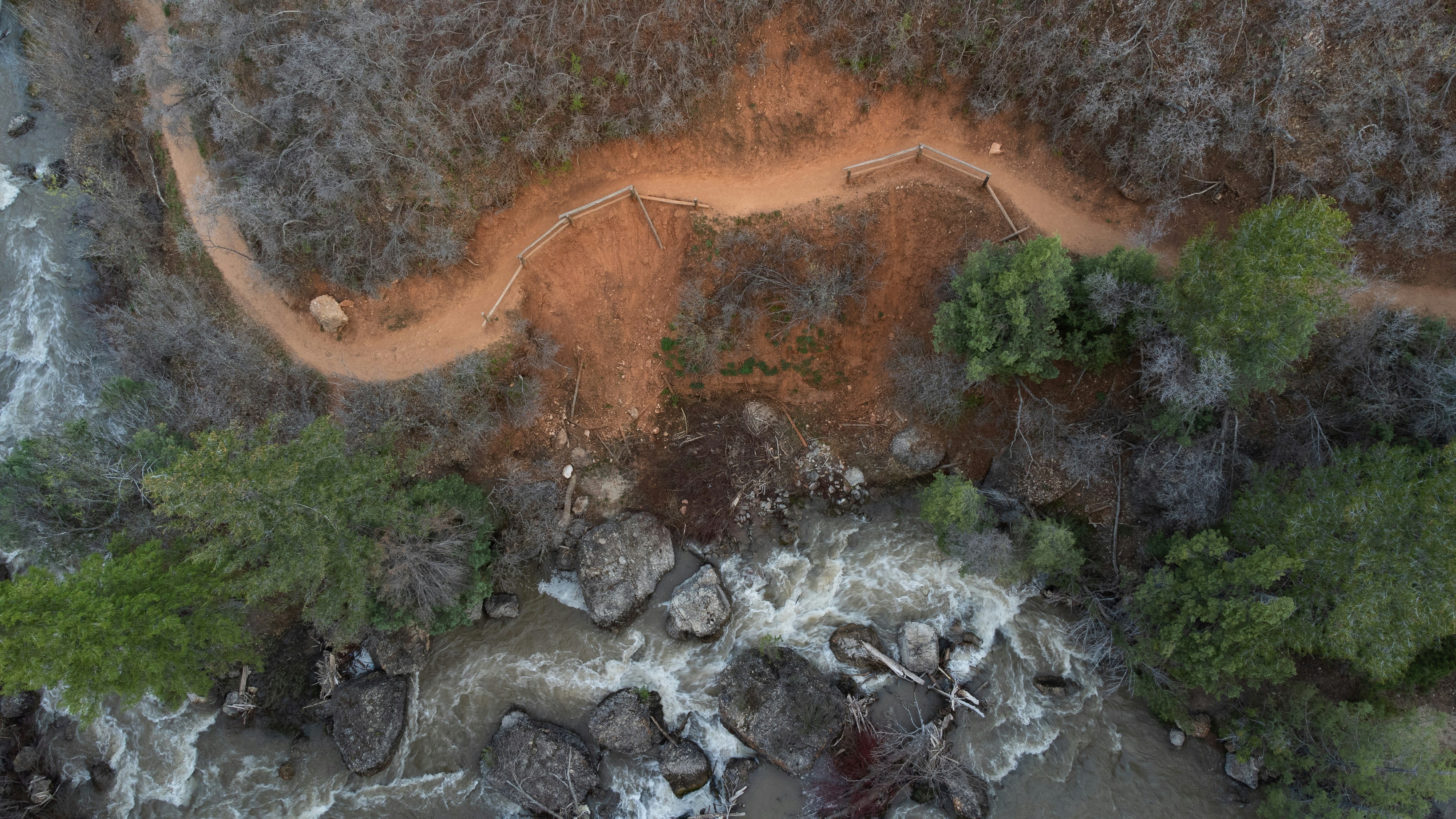 An aerial view of a river and a dirt road