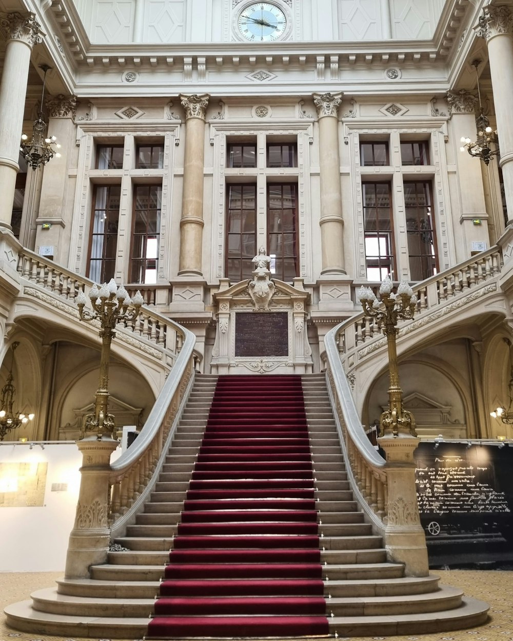 a red carpeted staircase in a large building