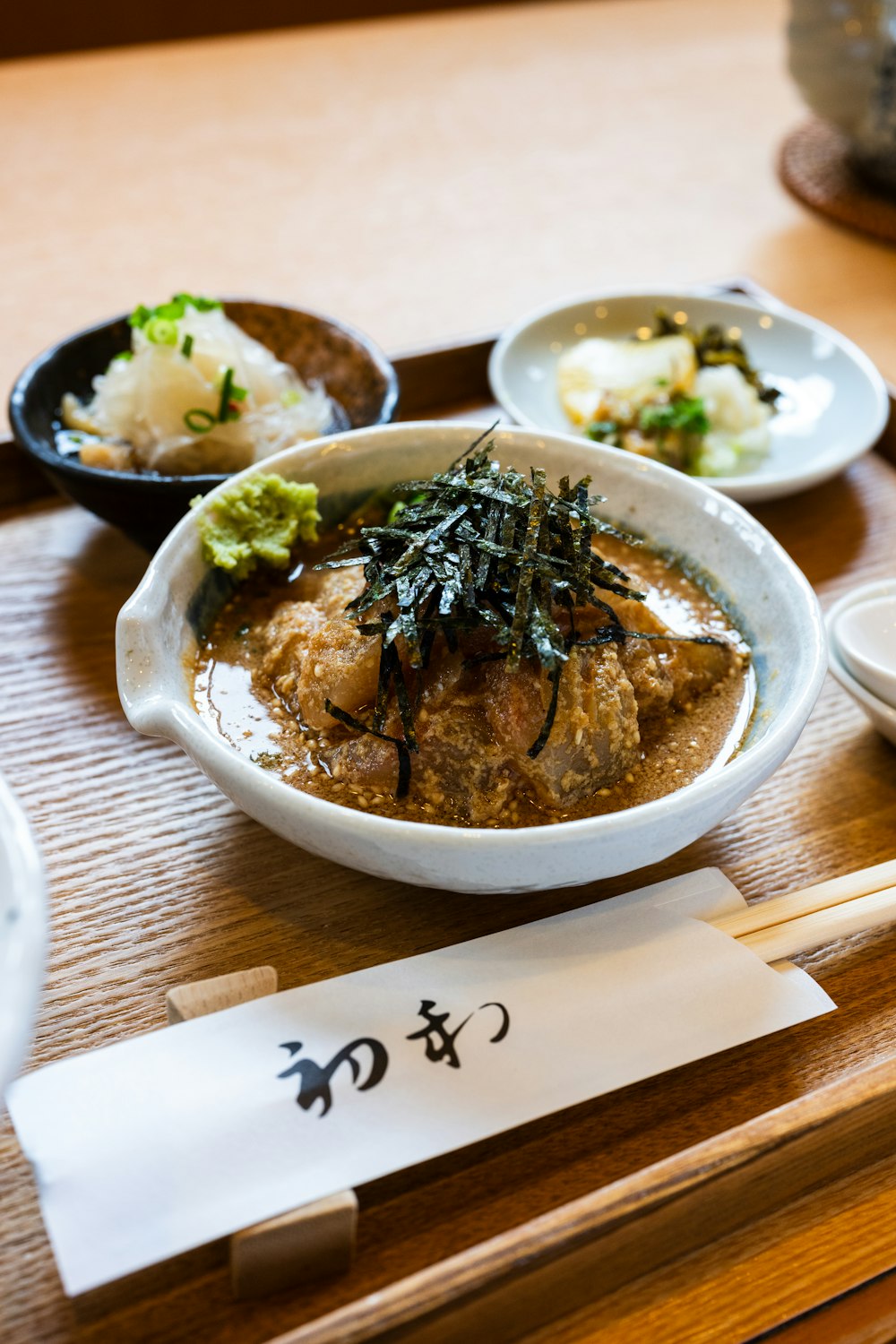 a bowl of food on a table with chopsticks