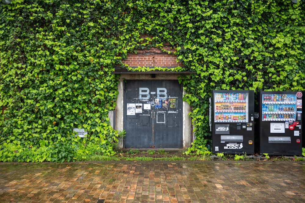 two vending machines sitting in front of a green wall