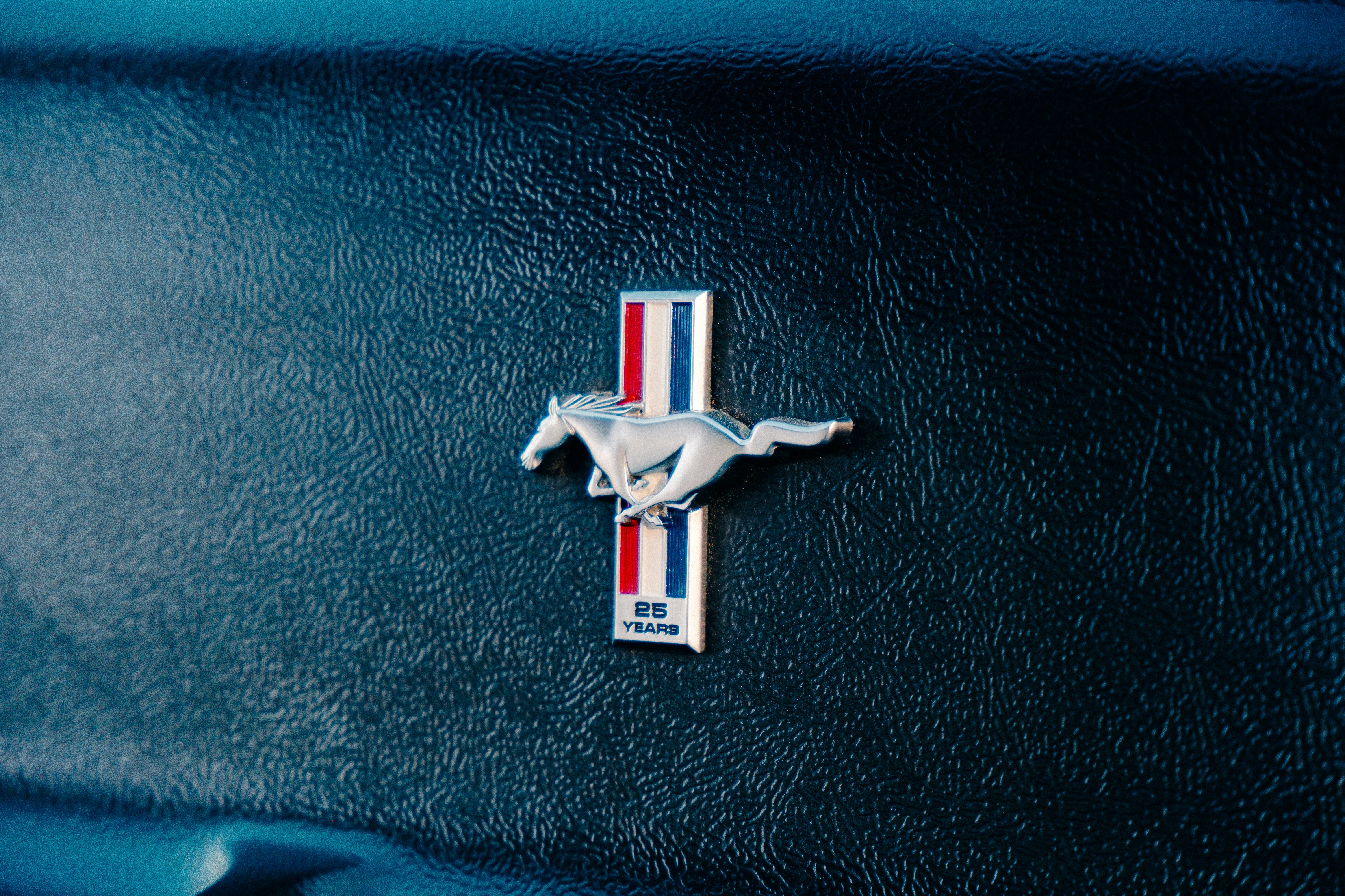 un gros plan d’un emblème de cheval sur une voiture