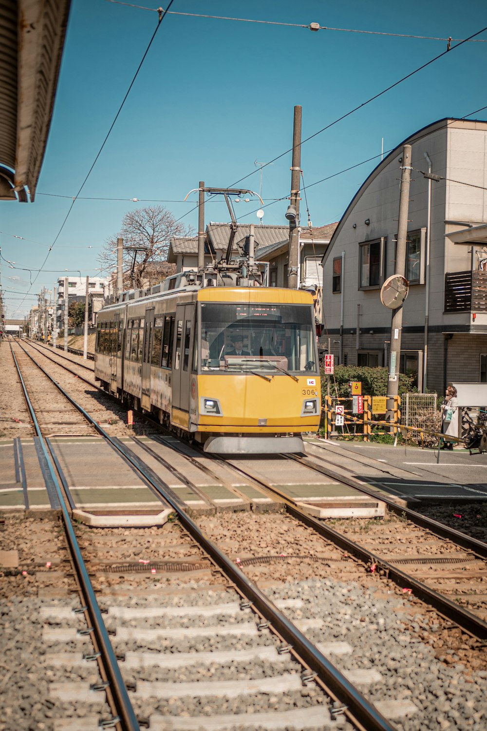 a yellow train traveling down train tracks next to a building