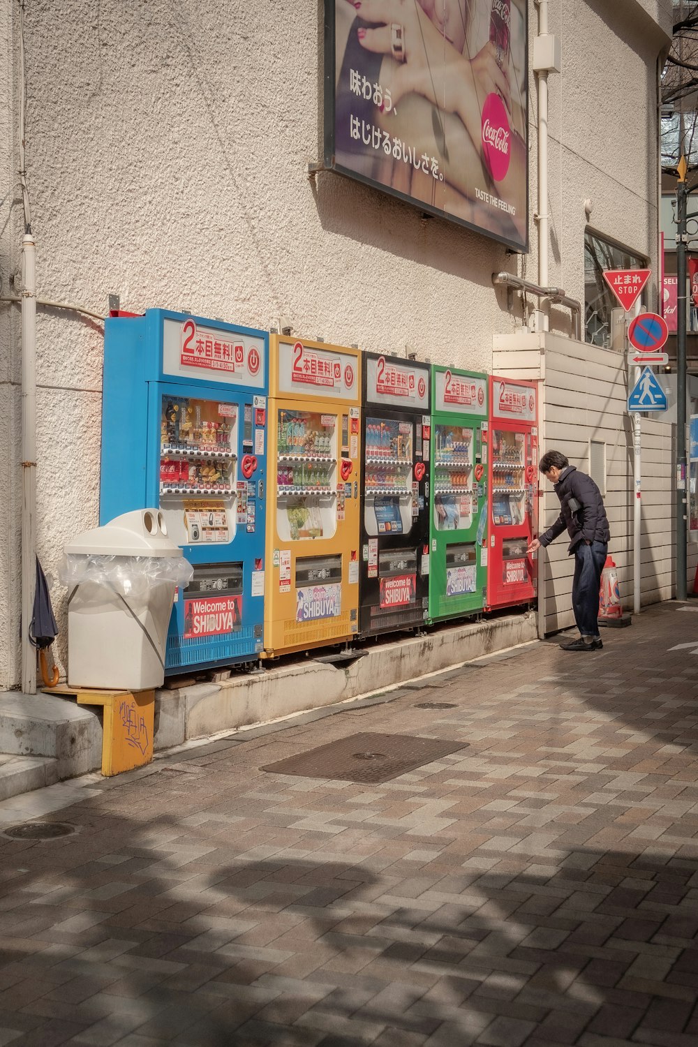 a man standing next to a row of vending machines