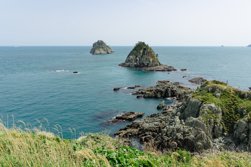 a large body of water surrounded by a lush green hillside