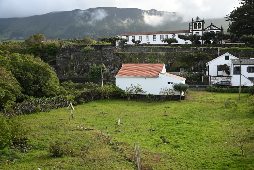 uma casa branca sentada no topo de uma colina verde exuberante