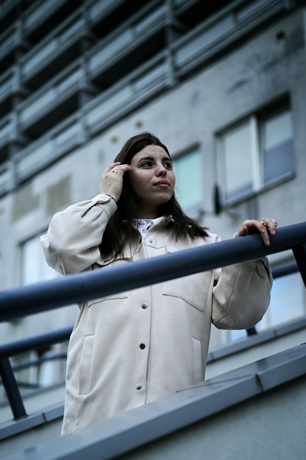 a woman in a white coat is talking on a cell phone