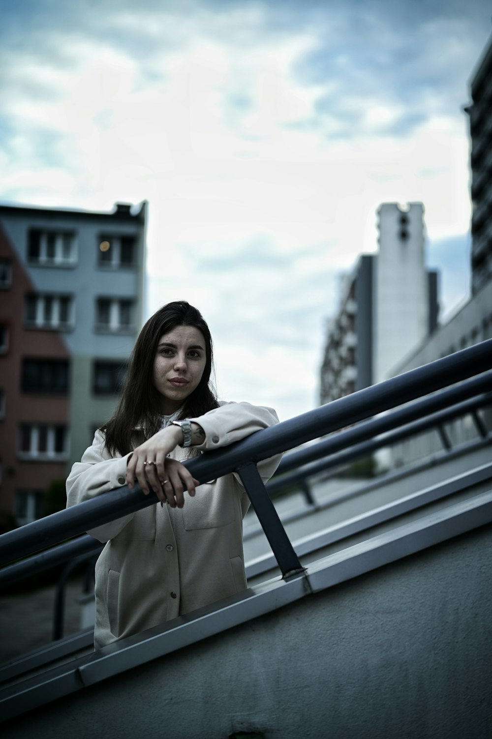 a woman leaning on a railing in a city