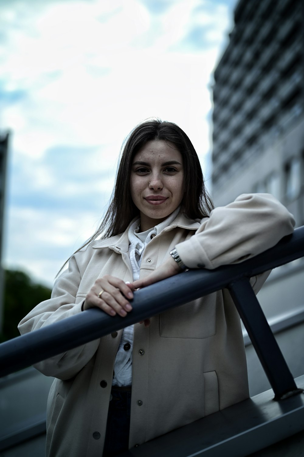 a woman leaning on a rail in front of a building