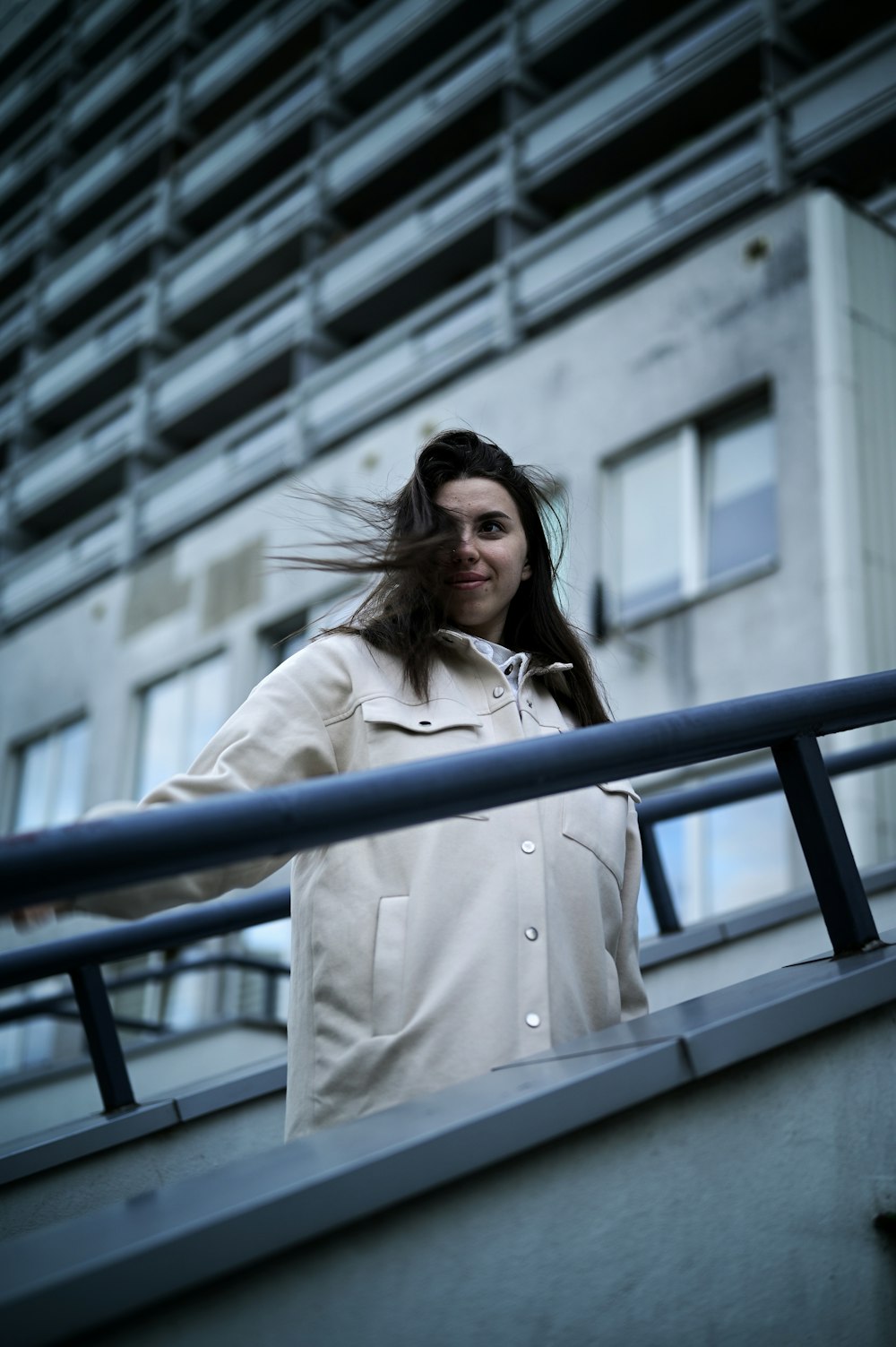 a woman with long hair standing on a balcony